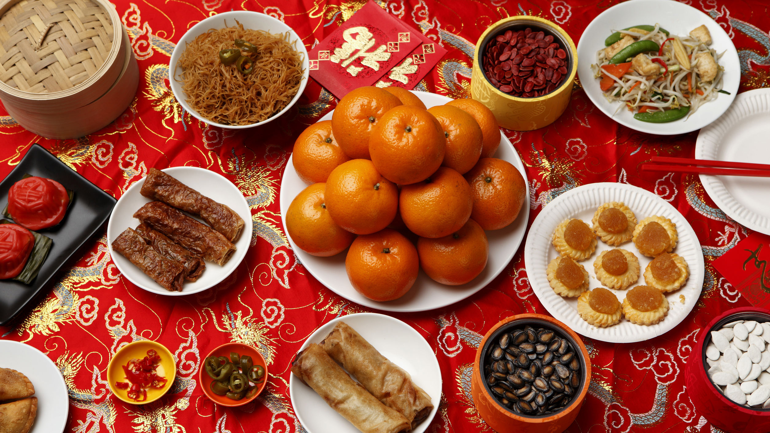 Chinese new year celebrations with mandarin oranges, pineapple tarts, yu sheng, and pencai.